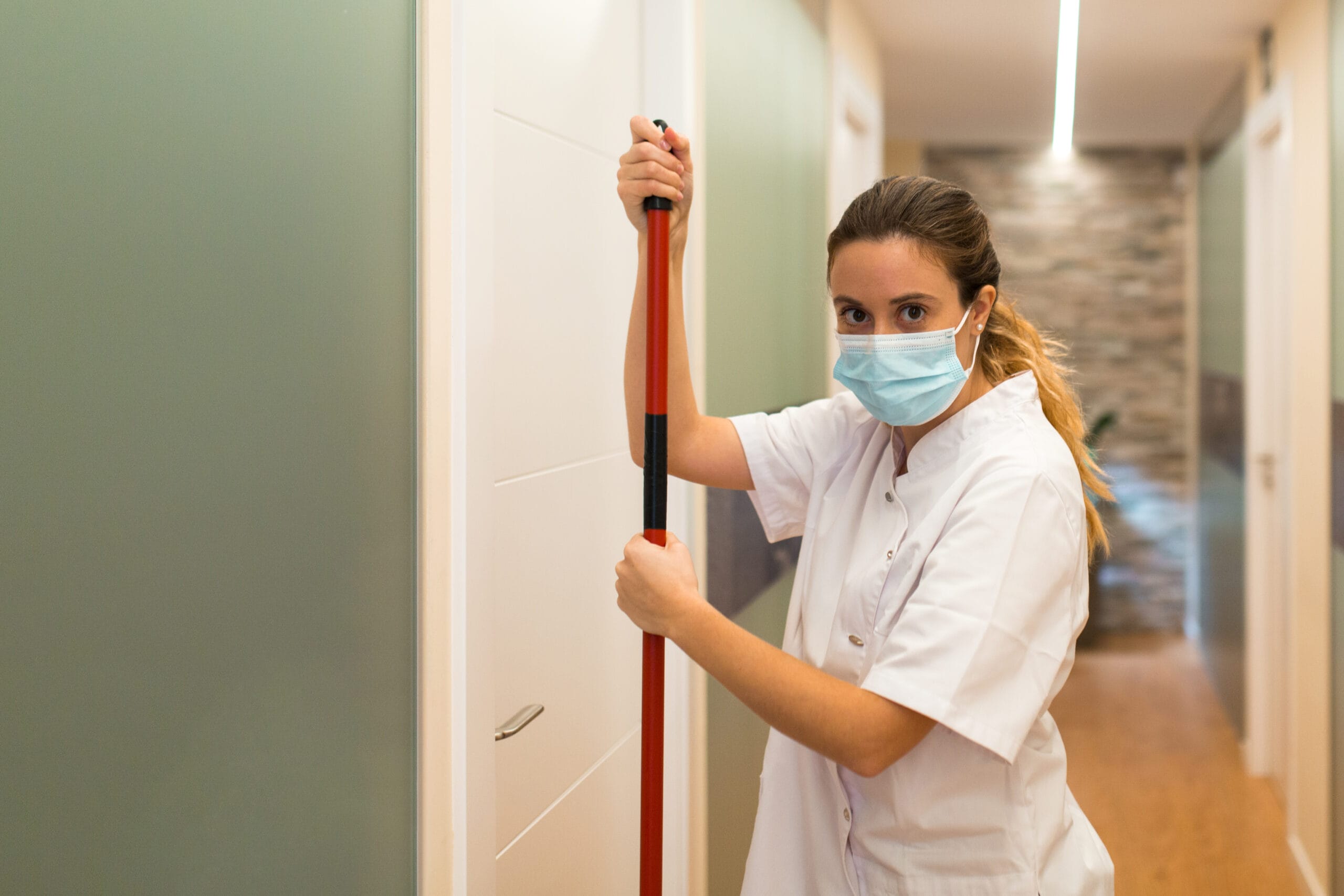 Woman cleaning hallway of clinic while looking at 2025 01 09 06 16 52 utc scaled